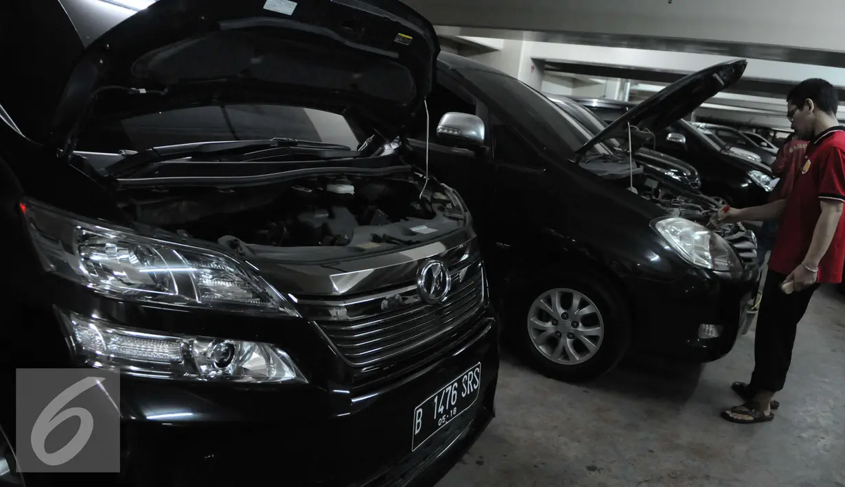 Petugas membersihkan mesin mobil hasil sitaan para tersangka kasus korupsi di Rumah Penyimpanan Benda Sitaan Negara, Jakarta, Selasa (6/12). Anggaran untuk perawatan Rupbasan yang saat ini teralokasi 20 juta pertahun. (Liputan6.com/Helmi Affandi)