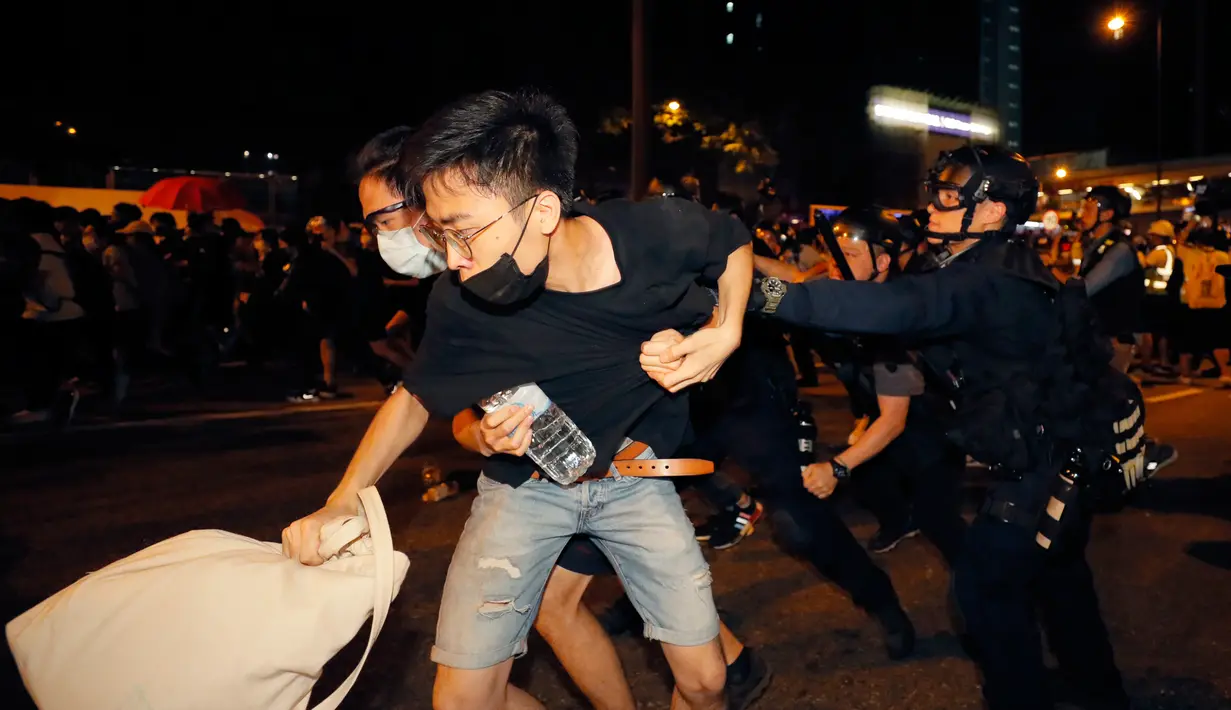 Polisi terlibat bentrok dengan pengunjuk rasa yang menolak RUU Ekstradisi di luar gedung parlemen, Hong Kong, Senin (10/6/2019). Unjuk rasa ini diselenggarakan oleh Front Hak Asasi Manusia (HAM) Sipil. (AP Photo/Kin Cheung)