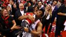 Pebasket Toronto Raptors, Kyle Lowry, menggendong putranya usai mengalahkan Milwaukee Bucks pada NBA Final Wilayah Timur di Scotiabank Arena, Toronto, Sabtu (25/5). Raptors menang 4-2 atas Bucks. (AFP/Gregory Shamus)
