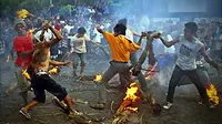 Sejumlah umat Hindu saling serang menggunakan api yang disulut pada &quot;bobok&quot; (seikat daun kelapa kering) saat tradisi perang api di Mataram, NTB, Senin (15/3). (Antara)