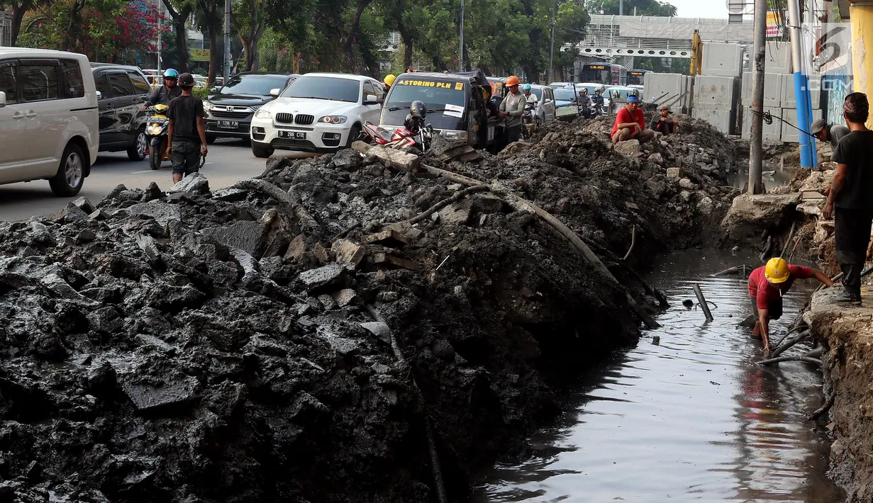 Pekerja membongkar saluran air (drainase) yang akan diperbaiki di jalan Hayam Wuruk, Jakarta Pusat, Selasa (20/11). Perbaikan dan pelebaran saluran air ini untuk mengantisipasi terjadinya banjir di kawasan tersebut saat hujan. (Liputan6.com/Johan Tallo)