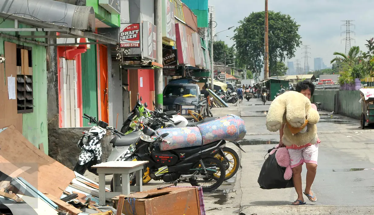 Seorang warga mengangkut barang miliknya di kawasan Kalijodo, Jakarta, Kamis (25/2). Hari ini, surat peringatan kedua (SP2) untuk mengosongkan/membongkar sendiri bangunan sudah terpasang di kawasan tersebut. (Lputan6.com/Gempur M Surya)