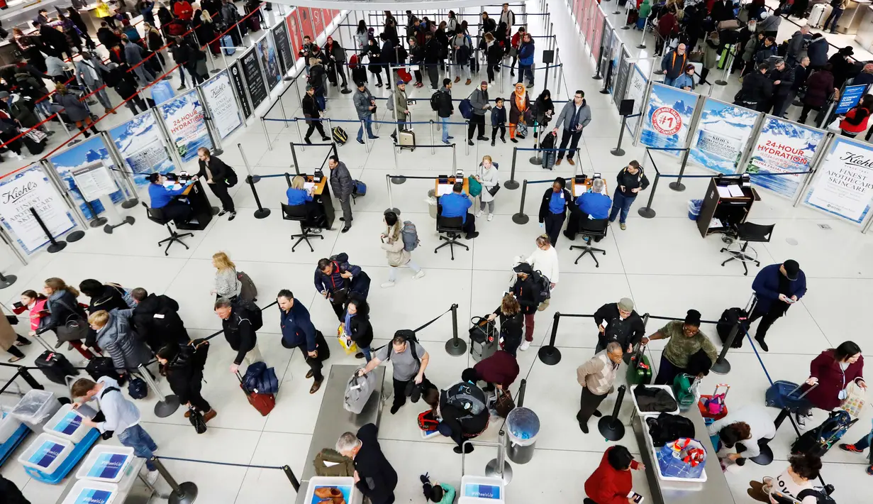 Wisatawan mengantre untuk melewati pos pemeriksaan keamanan di Bandara Internasional John F. Kennedy, New York, Rabu (21/11). Masyarakat Amerika mulai bergegas pulang ke kampung halamannya alias mudik untuk merayakan Thanksgiving Day. (AP/Mark Lennihan)