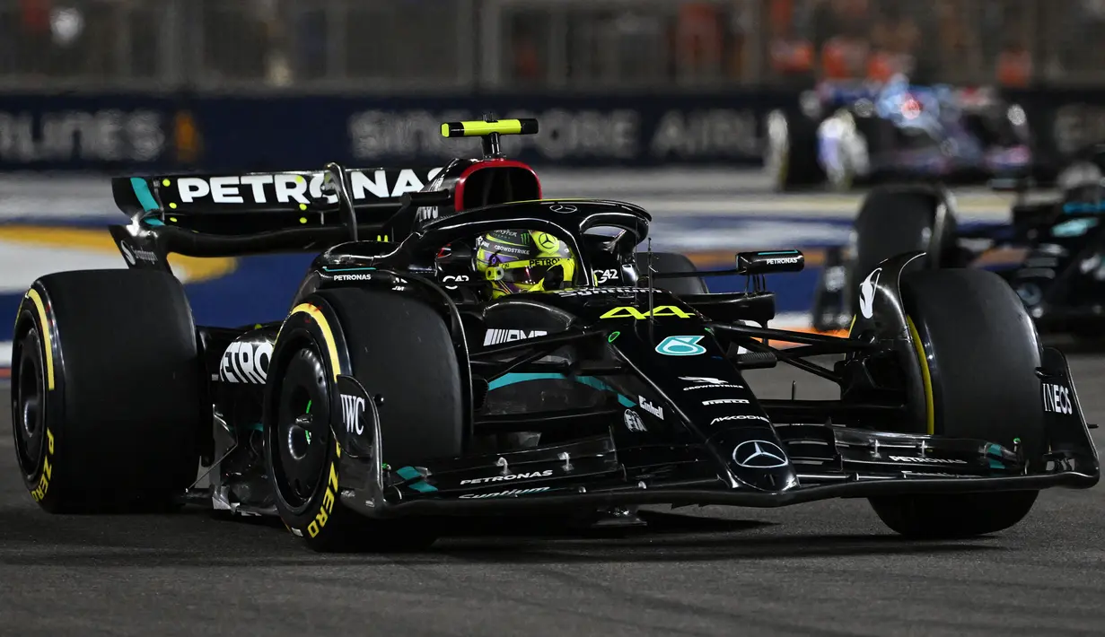 Pembalap tim Merceds, Lewis Hamilton memacu mobilnya dalam balapan F1 GP Singapura 2023 di Marina Bay Street Circuit, Singapura, Minggu (17/9/2023) malam WIB. (AFP/Roslan Rahman)