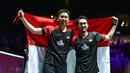 Pasangan Indonesia, Hendra Setiawan/Mohammad Ahsan melakukan selebrasi usai menjuarai Kejuaraan Dunia Bulutangkis 2019 setelah mengalahkan wakil Jepang, Takuro Hoki/Yugo Kobayashi, Minggu (25/8). Indonesia menang 25-23, 9-21, 21-15. (AFP/Fabrice Coffrini)