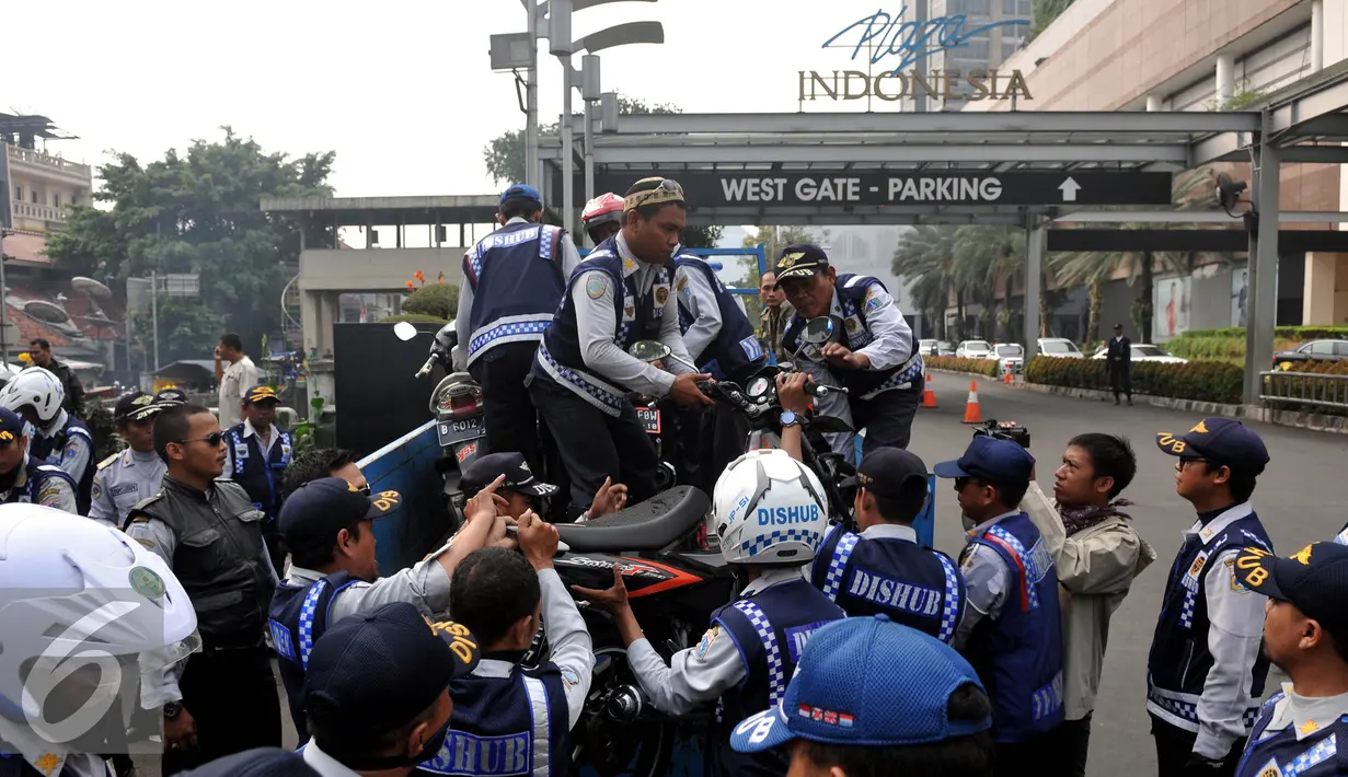 Petugas Dishub, mengangkut sepeda motor yang nekat parkir liar di kawasan Tanah Abang, Jakarta, Jumat (12/6/2015). Razia gabungan Dishub, Garnisun dan Satlantas bertujuan untuk mengantisipasi arus lalu lintas yang kerap macet. (Liputan6.com/Johan Tallo)