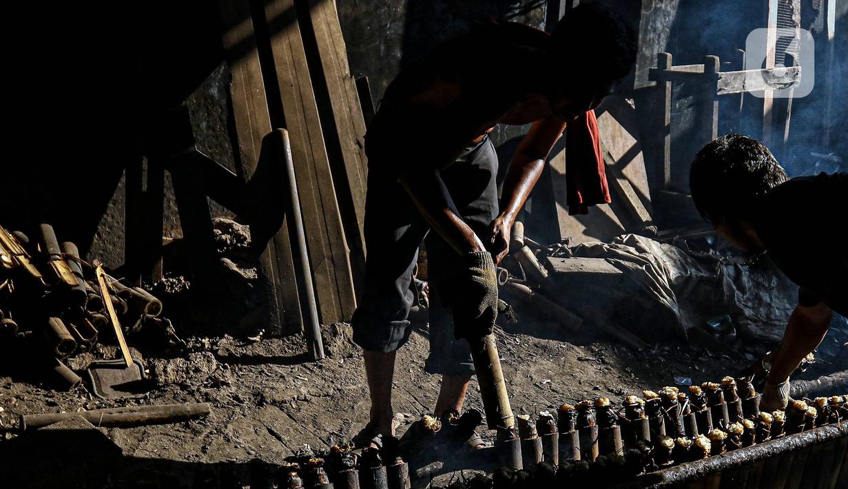 Pekerja melakukan pembakaran lemang bambu di Jalan Kramat Raya, Senen, Jakarta Pusat, Rabu (6/4/2022). Selama Ramadhan, pembuat lemang mampu memproduksi hingga 300 buah dalam sehari, meningkat hingga tiga kali lipat dari hari biasa. (Liputan6.com/Herman Zakharia)