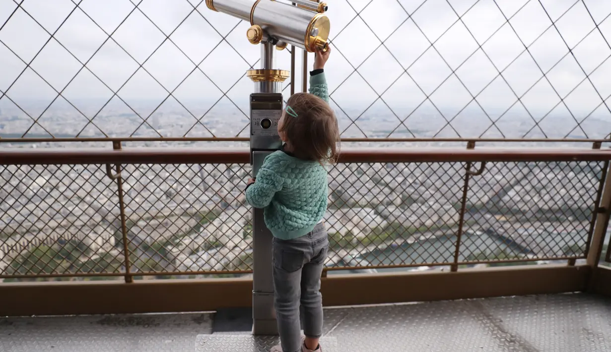 Seorang anak bermain di puncak Menara Eiffel di Paris, Prancis (15/7/2020). Puncak Menara Eiffel dibuka kembali untuk umum pada Rabu (15/7) setelah ditutup selama lebih dari tiga bulan karena COVID-19. (Xinhua/Gao Jing)