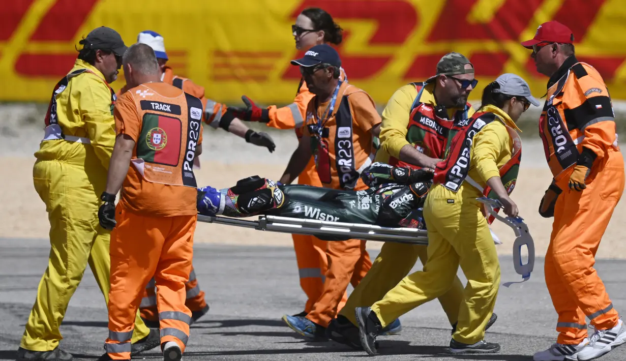 Pebalap CryptoData Aprilia, Miguel Oliveira ditandu petugas trek setelah mengalami tabrakan dengan pebalap Repsol Honda, Marc Marquez pada balapan MotoGP Portugal 2023 di Sirkuit Internasional Algarve, Portimao, Portugal, Minggu (26/3/2023). (AFP/Patricia De Melo Moreira)