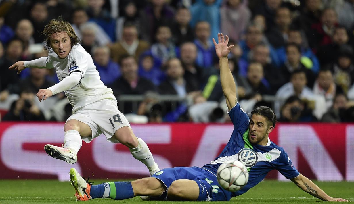 Pemain Real Madrid, Luka Modric, dihadang pemain Wolfsburg, Ricardo Rodriguez pada leg kedua perempat final Liga Champions di Stadion Santiago Bernabeu, Madrid, Rabu (13/4/2016) dini hari WIB. (AFP/Javier Soriano)