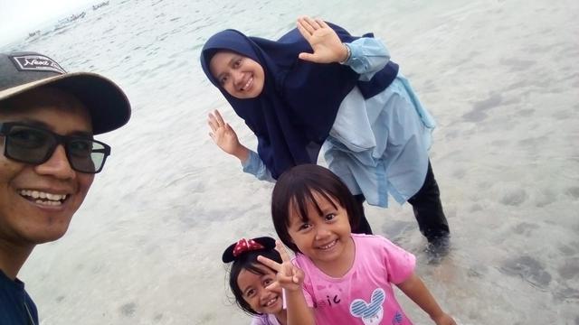 Beberapa pengunjung pantai Pangandaran, nampak ceria menikmati sajian alam pasir putih di kawasan Pantai Barat, Pangandaran, Jawa Barat