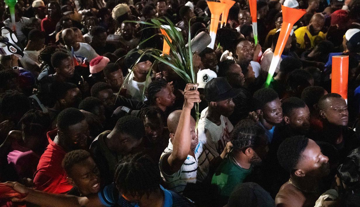 Diketahui, penampilan pertama Timnas Haiti terjadi pada Piala Dunia FIFA 1974 di Jerman Barat. Tampak dalam foto, warga Haiti turun ke jalan-jalan di Port-au-Prince saat merayakan lolosnya tim nasional mereka di putaran final Piala Dunia 2026, pada Selasa 18 November 2025 waktu setempat. (Clarens SIFFROY/AFP)