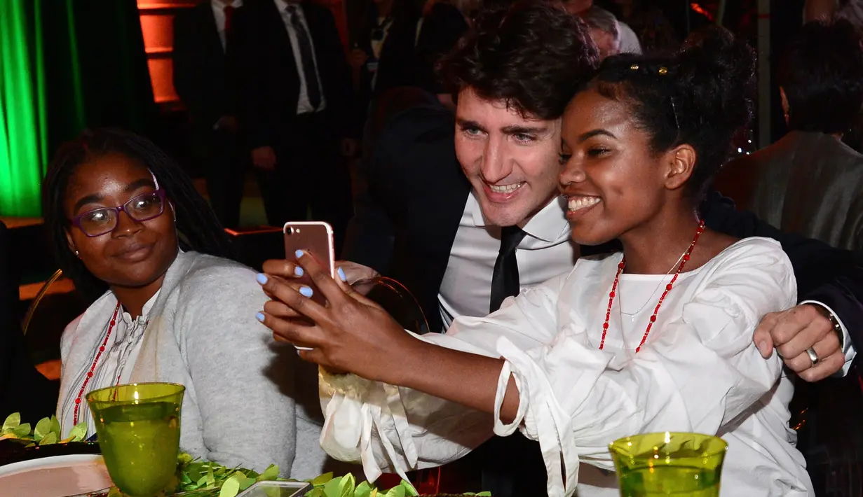 Seorang siswi SMA mengajak Perdana Menteri (PM) Kanada, Justin berswafoto ketika menghadiri acara Fortune Most Powerful Women Summit 2017 di Washington, Selasa (10/10). (AP Photo/Sait Serkan Gurbuz)