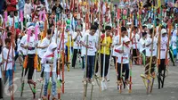 Sejumlah anak SD dan SMP meramaikan pemecahan rekor dunia egrang yang termasuk dalam rangkaian penyelenggaraan TAFISA World Games 2016 di Kemayoran, Jakarta, Sabtu (8/10). Pemecahan rekor Guinness Book itu diikuti 2.016 anak. (Liputan6.com/Faizal Fanani)