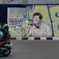 Pengendara melintas di depan mural berwajah mirip Presiden Joko Widodo atau Jokowi yang matanya tertutup masker di jembatan layang Pasupati, Kota Bandung, Rabu (25/8/2021). (Liputan6.com/Huyogo Simbolon)