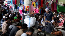 Umat muslim mendengarkan ceramah sebelum melaksanakan salat Jumat di pasar Tanah Abang, Jakarta, Jumat (9/6). Dikarenakan membeludaknya jamaah yang ingin beribadah mereka terpaksa melakukan sholat di antara kios-kios pasar. (Liputan6.com/Johan Tallo)