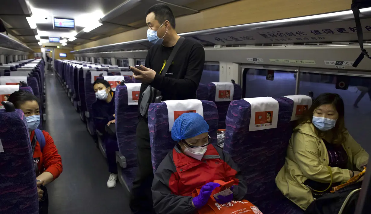 Penumpang mengenakan masker saat menaiki kereta pertama yang meninggalkan Stasiun Hankou, Wuhan, Provinsi Hubei, China, Rabu (8/4/2020). Setelah 11 minggu lockdown, layanan kereta di kota yang menjadi titik awal pandemi virus corona COVID-19 ini kembali beroperasi. (AP Photo/Ng Han Guan)