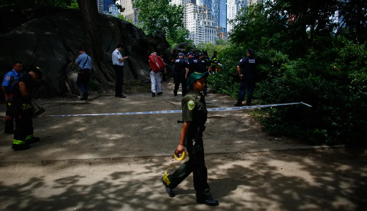 Petugas mengamankan lokasi ledakan di Central Park, New York, Minggu (3/7). Sementara itu, polisi melakukan penyelidikan setelah ledakan mengguncang bagian tenggara taman itu di dekat sudut 5th Avenue dan 62th Street. (Kena Betancur/AFP)