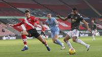 Pemain Manchester United, Mason Greenwood, menendang bola saat melawan Southampton pada laga Liga Inggris di Stadion St. Mary's, Minggu (29/11/2020). MU menang dengan skor 3-2. (Naomi Baker, Pool via AP)
