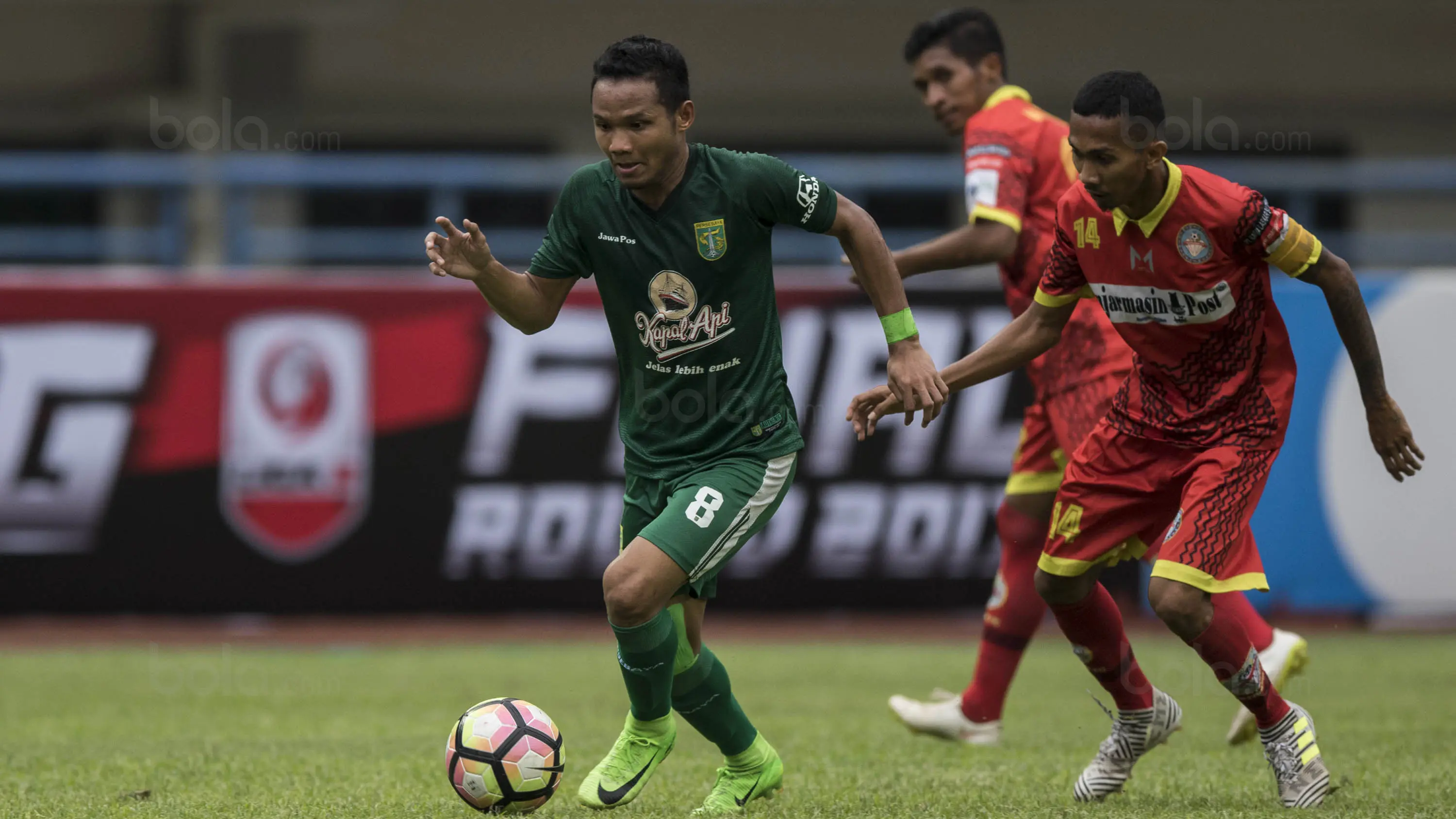 Gelandang Persebaya, Oktafianus Fernando, menghindari kejaran pemain Martapura FC pada laga semifinal Liga 2 2017 di Stadion GBLA, Bandung, Sabtu (25/11/2017). Persebaya menang 3-1 atas Martapura FC. (Bola.com/Vitalis Yogi Trisna)