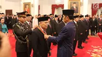 Presiden Joko Widodo atau Jokowi (kanan) menyematkan tanda kehormatan kepada tokoh nasional di Istana Negara, Jakarta, Kamis (15/8/2019). Sebanyak 29 orang mendapat gelar tanda kehormatan Bintang Mahaputra Utama dan Bintang Jasa Utama dalam rangka peringatan HUT ke-74 RI. (Liputan6.com/Angga Yuniar)