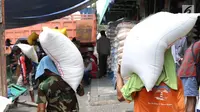 Seorang kuli angkut memanggul beras di Pasar Induk Cipinang, Jakarta, Senin (25/9). Pedagang beras Cipinang sudah menerapkan dan menyediakan beras medium dan beras premium sesuai harga eceran tertinggi (HET). (Liputan6.com/Angga Yuniar)
