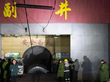 Tim penyelamat dan staf menunggu di luar lokasi ledakan tambang batu bara di Pingyao, di provinsi Shanxi utara China (19/11/2019). Kantor berita resmi China, Xinhua melaporkan ledakan tambang batu bara menewaskan 15 orang. (AFP Photo)