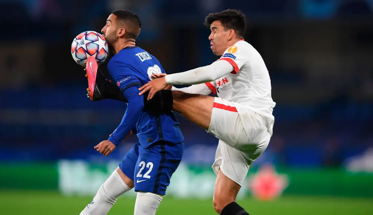 Gelandang Chelsea, Hakim Ziyech dan pemain Sevilla Marcos Acuna berebut bola pada laga perdana Grup E Liga Champions 2020 di Stadion Stamford Bridge, Rabu (21/10/2020) dini hari WIB. Chelsea harus berbagi angka dengan tim tamu Sevilla setelah bermain imbang tanpa gol. (Mike Hewitt/Getty, Pool via AP