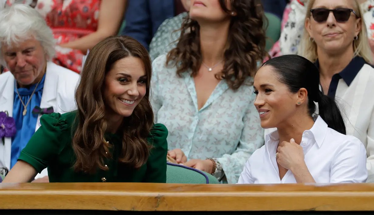 Duchess of Cambridge Kate Middleton (kiri) dan Duchess of Sussex Meghan Markle tertawa saat menyaksikan pertandingan final tunggal putri Wimbledon 2019 antara Serena Williams dengan Simona Halep di All England Lawn Tennis and Croquet Club, London, Inggris, Sabtu (13/7/2019). (BEN CURTIS/POOL/AFP)