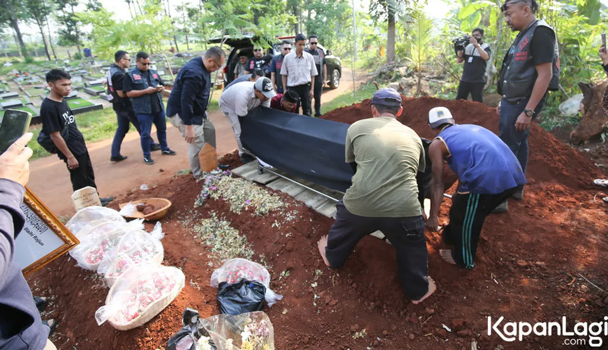 Prosesi pemakanan berjalan lancar di warnai isak tangis keluarga dan sahabat. Keranda dengan kain hitam yang berisi jenazah pria 48 tahun itu diletakkan disamping pusara sebelum dimakamkan. [Foto: KapanLagi.com®/Bayu Herdianto]
