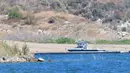 Sebuah kapal sheriff Ventura County terlihat di dekat teluk kecil di Danau Piru, California, Senin (13/7/2020). Jasad aktris Glee Naya Rivera yang dinyatakan menghilang pada 8 Juni 2020 lalu telah ditemukan tewas di Danau Piru pada Senin (13/7). (Frederic J. BROWN / AFP)