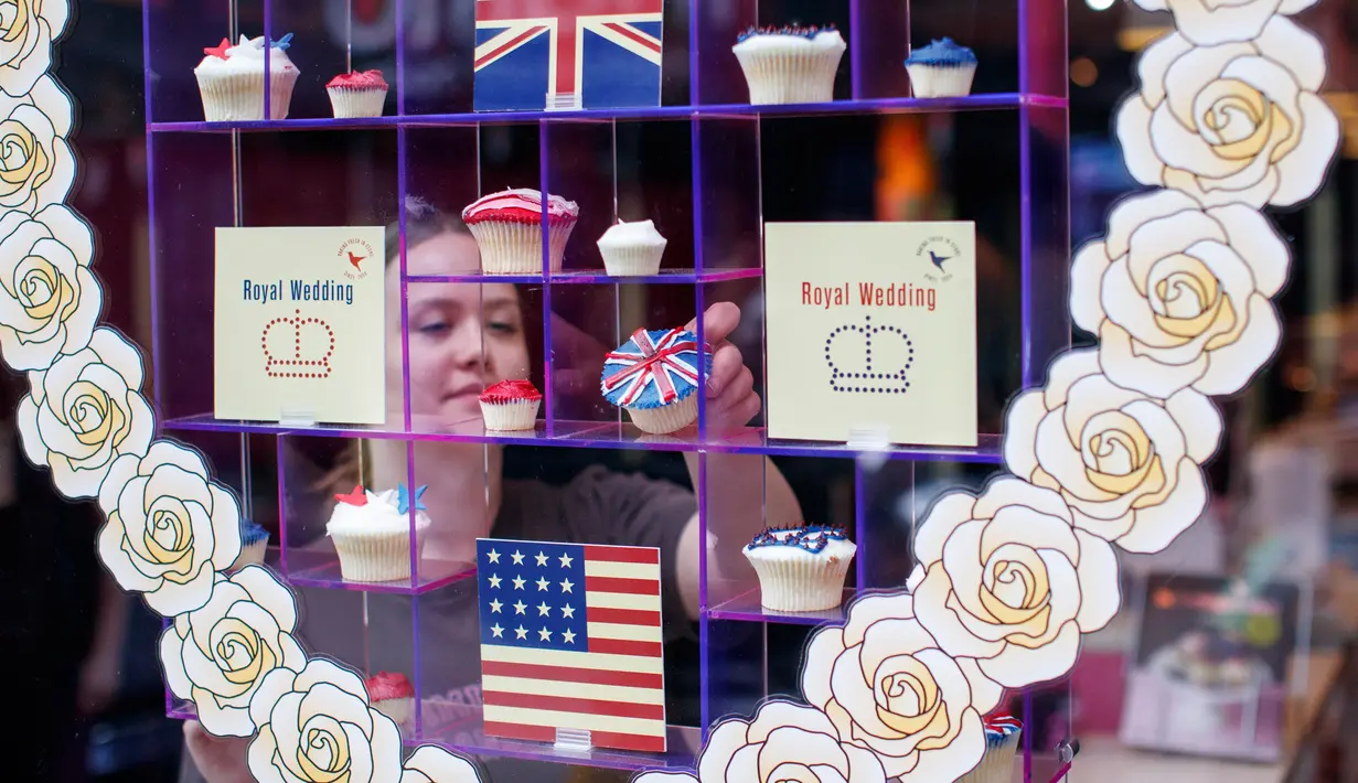Karyawan menata cupcakes edisi khusus untuk menghormati pernikahan Pangeran Harry dan Meghan Markle di Hummingbird Bakery, London, 11 Mei 2018. Pernikahan Harry dan Meghan digelar 19 Mei mendatang di Kapel St. George, Istana Windsor. (AFP/Tolga AKMEN)