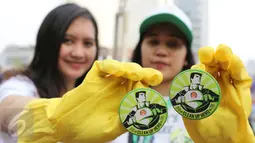 Dua orang relawan menunjukkan pin Clean Up Jakarta Day (CUJD) 2015 di Bunderan Hotel Indonesia, Jakarta, minggu (18/10/2015). Sebanyak 15.000 relawan mengikuti kegiatan Clean Up Jakarta Day 2015. (LIputan6.com/Herman Zakharia)
