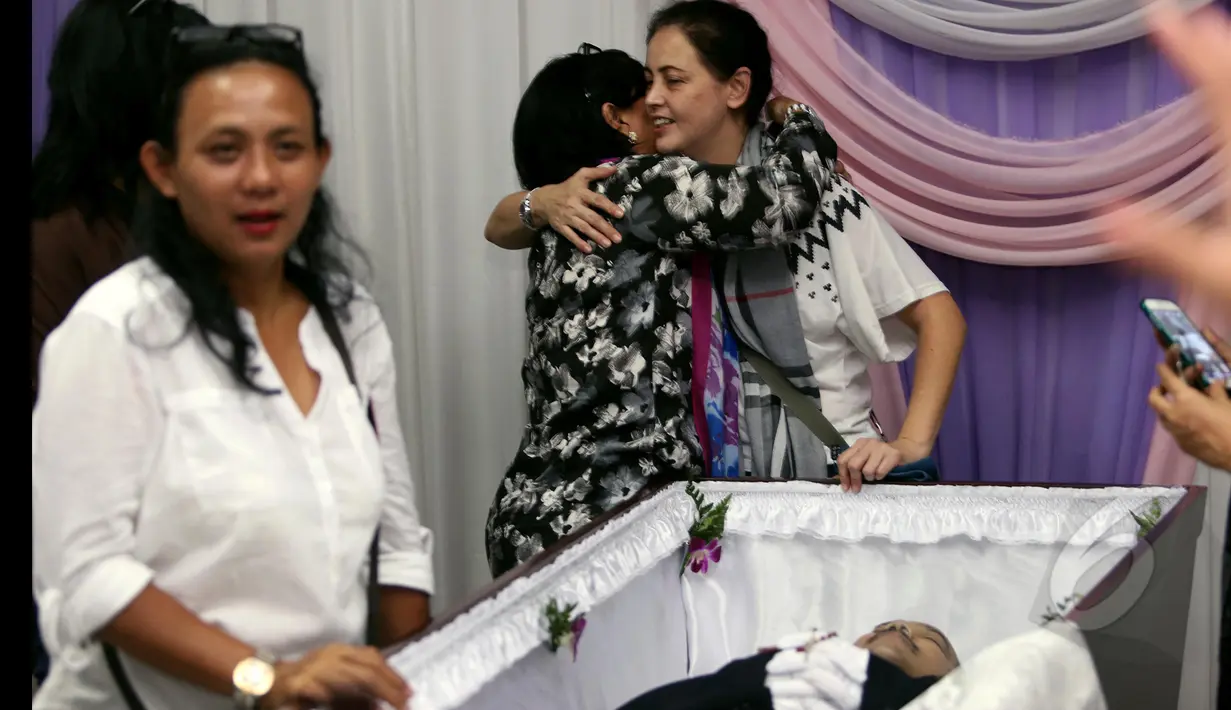 Kerabat yang datang memberikan pelukan kepada Istri James Sahertian, Roweina saat di Rumah Duka RSPP Jakarta Selatan, Senin (13/4/2015). (Liputan6.com/Faisal R Syam)