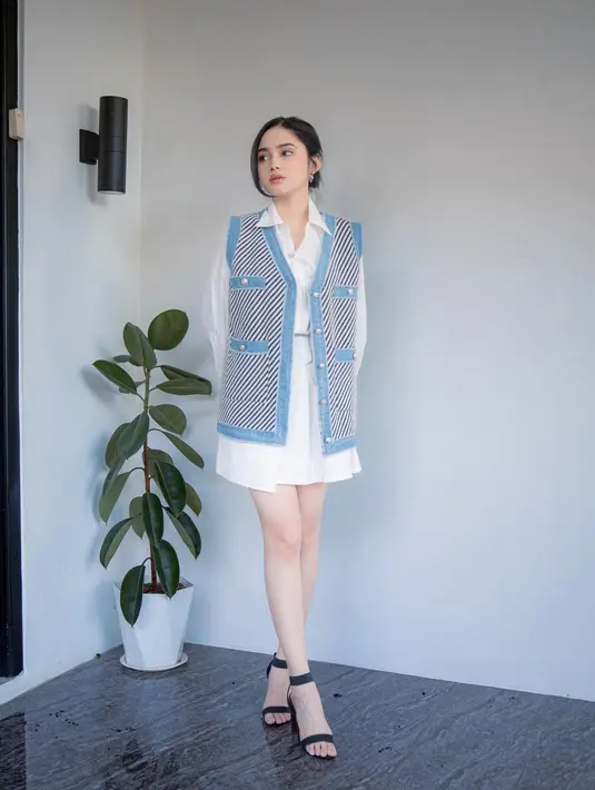 Penampilan super chic dari Syifa Hadju. Ia mengenakan kemeja lengan panjang yang serasi dengan pleated mini skirtnya yang berwarna putih, ditumpuk dengan vest biru. [Foto: Instagram/syifahadju]