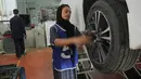 Montir perempuan Pakistan Uzma Nawaz (24) memperbaiki mobil di sebuah bengkel kota Multan, 1 September 2018. Pencapaiannya amat langka bagi para perempuan di negeri patriarki tersebut berjuang keras untuk mendapatkan kesetaraan hak. (S.S. Mirza/AFP)