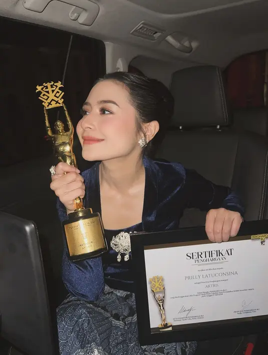 Rambutnya ditata dengan gaya high bun, belah tengah, dan menghadirkan tampilan yang sleek dan rapi. [Foto: Instagram/prillylatuconsina96]