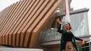 Kebaya hitam-nya dipadukan dengan kain batik bermotif bunga penuh warna dan selendang hijau menjuntai, menciptakan siluet yang elegan sekaligus membumi.   [@arieltatum].