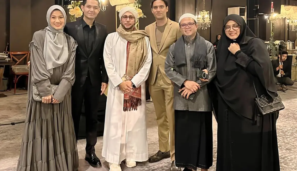 Icha Soebandono tampil mengenakan dress panjang warna dark grey yang dipadukan hijab warna light grey. Sementara sang suami, Dude Herlino mengenakan setelan jas hitam. [@farahacarpetofficial]