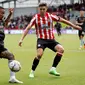 Striker Arsenal, Gabriel Jesus, dikawal oleh bek Brentford, Aaron Hickey, saat kedua tim berhadapan pada laga pekan kedelapan Premier League 2022/2023 di Gtech Community Stadium, London, Minggu (18/9/2022). (Ian Kington / AFP)