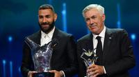 Penyerang Real Madrid, Karim Benzema bersama pelatihnya Carlo Ancelotti berpose dengan penghargaan Pemain dan Pelatih Terbaik Eropa 2021-2022 dalam upacara pengundian Liga Champions di Istanbul, Turki, Kamis (25/8/2022). (AFP/Ozan Kose)