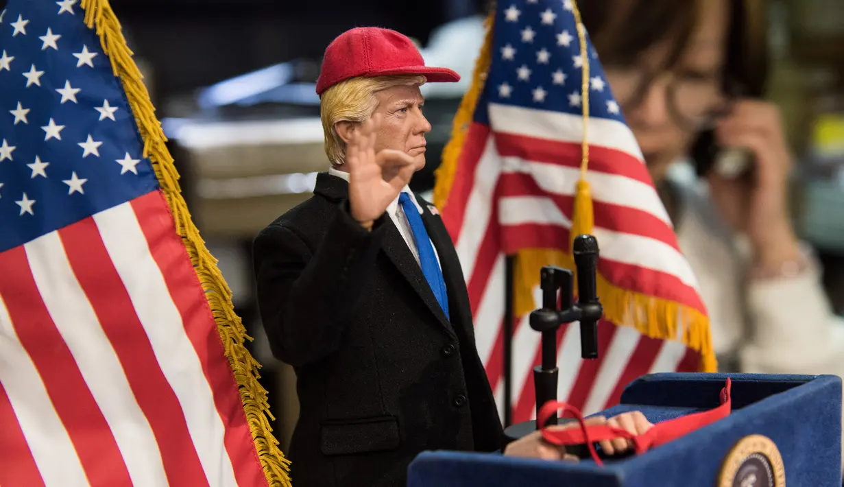 Boneka Presiden AS Donald Trump saat pidato di toko mainan, Hong Kong (3/2). Pembuat boneka di Hong Kong yang sering menciptakan boneka pemimpin dunia yang kontroversial telah membuat boneka Donald Trump. (AFP Photo/Anthony Wallace)