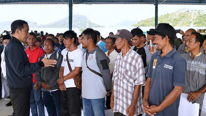 Presiden Joko Widodo (kiri) berbincang dengan nelayan Natuna saat melakukan kunjungan kerja di Sentra Kelautan Perikanan Terpadu (SKPT), Natuna, Kepulauan Riau, Rabu (8/1/2020). Kunjungan Jokowi tersebut pascakapal coast guard milik China berlayar di perainan laut Natuna (HO/PRESIDENTIAL PALACE/AFP)