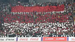 Para suporter Indonesia memberikan dukungan kepada Timnas Indonesia U-22 dengan membuat konfigurasi dan membentangkan bendera Merah Putih raksasa pada laga final cabor sepak bola SEA Games 2023 menghadapi Thailand di National Olympic Stadium, Phnom Penh, Kamboja, Selasa (16/5/2023). (Bola.com/Abdul Aziz)
