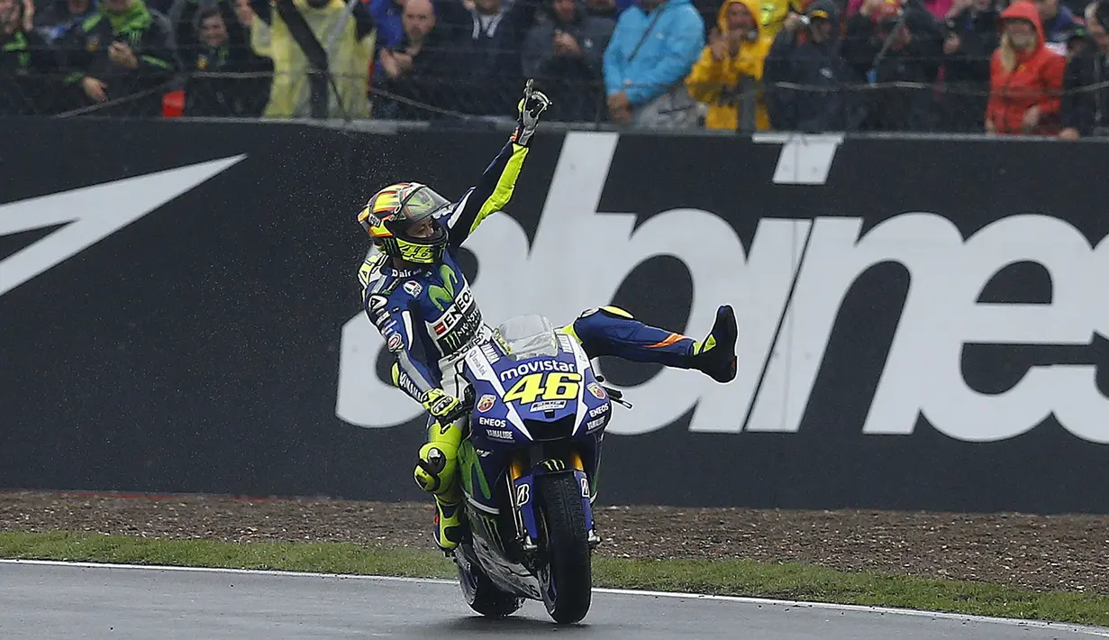Pembalap Yamaha, Valentino Rossi melakukan selebrasi setelah berhasil finis pertama pada balapan Moto Gp seri ke-12 di sirkuit Silverstone (30/8/2015). Posisi kedua dan ketiga diduduki Danilo Petrucci dan  Andrea Dovizioso. (REUTERS/Darren Staples)