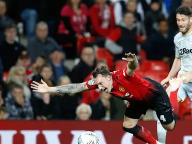 Pemain Manchester United, Phil Jones terjatuh saat berebut bola dengan pemain Derby County, David Nugent di Piala Liga Inggris di Old Trafford, Manchester, Inggris, Selasa (25/9). (Martin Rickett/PA via AP)