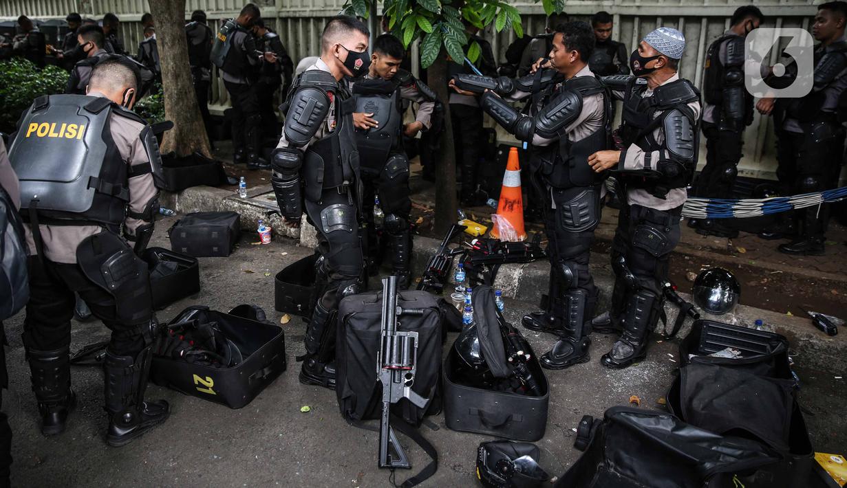 Personel Brimob bersiap mengenakan perlengkapan pelindung diri di Kawasan Bundaran HI, Jakarta, Selasa (13/10/2020). Sebanyak kurang lebih 12 ribu personel gabungan TNI, Polri dan Pemprov DKI Jakarta diterjunkan mengawal aksi tolak Undang-Undang Cipta Kerja Omnibus Law. (Liputan6.com/Faizal Fanani)