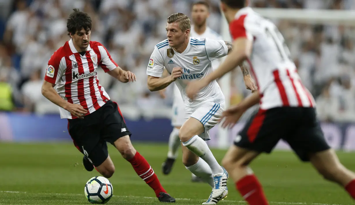 Pemain Real Madrid, Toni Kroos (tengah) mencoba menerobos pertahanan Athletic Bilbao pada lanjutan La Liga Santander di Santiago Bernabeu stadium, Madrid, (18/4/2018). Real Madrid bermain imbang 1-1 dengan Bilbao. (AP/Francisco Seco)