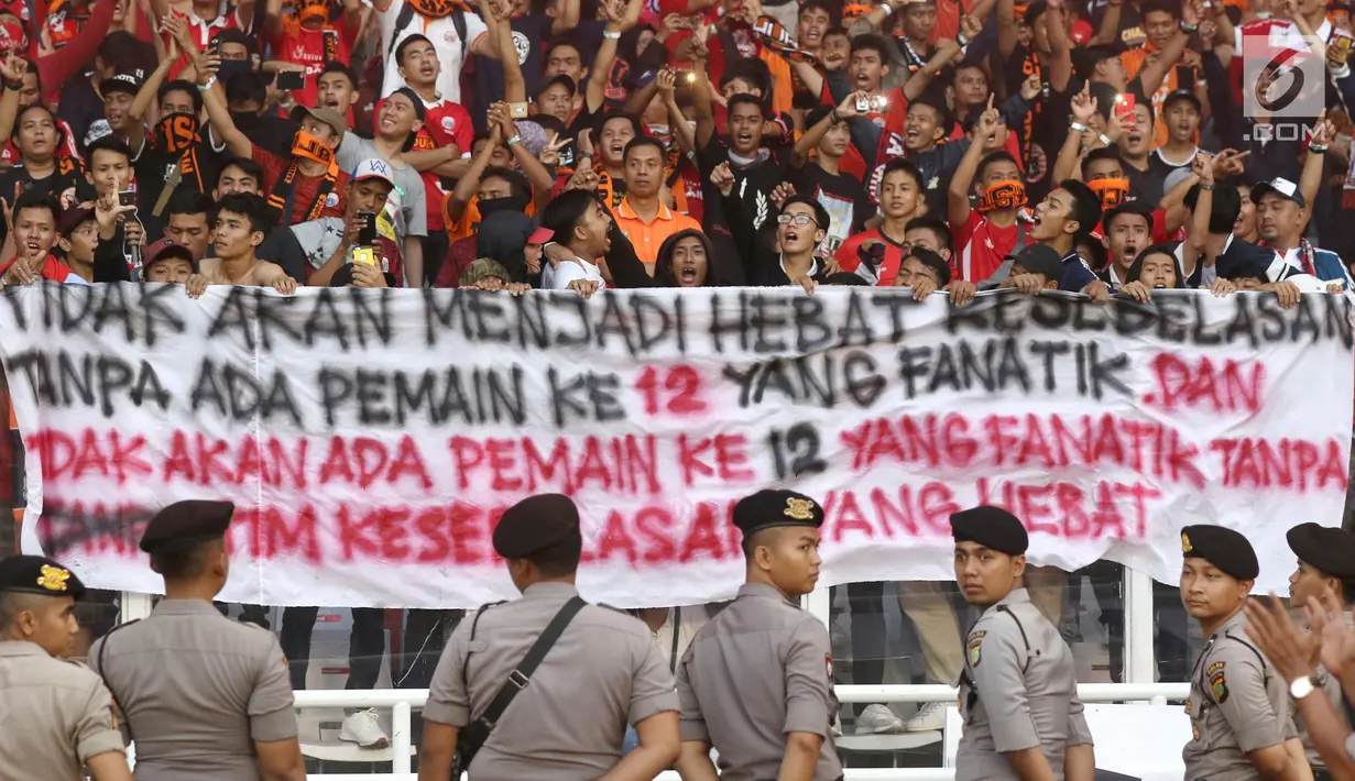 Suporter tim Macan Kemayoran membentangkan spanduk saat merayakan gelar juara Go-Jek Liga 1 Indonesia 2018 bersama Bukalapak yang diraih Persija di Stadion GBK, Jakarta, Minggu (9/12). Persija meraih juara dengan 62 poin. (Liputan6.com/Helmi Fithriansyah)