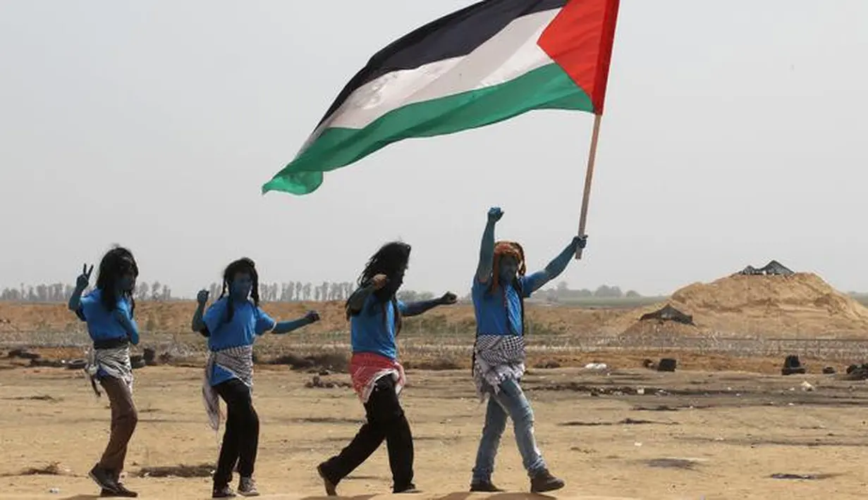 Warga Palestina bergaya seperti karakter dari film "Avatar" mengibarkan bendera selama protes menuntut hak untuk kembali ke kampung halaman mereka di perbatasan Israel-Gaza, Timur Khan Yunis di Gaza selatan Strip, (4/5). (AFP Photo/Said Khatib)